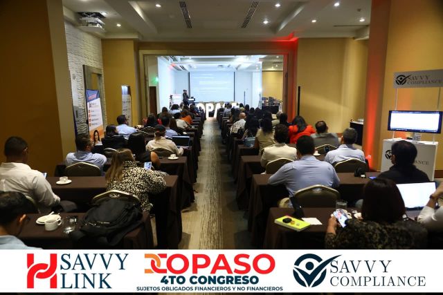 Full view of the COPASO 2026 room from the back, with the stage screen at the front