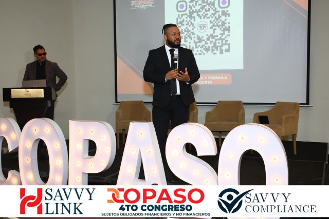 The COPASO 2026 moderator with the microphone in front of the QR code for asking questions, with Chiragx at the lectern