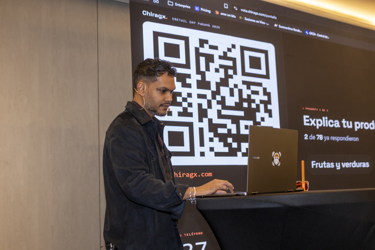 Chiragx on stage at eRetail Day Panamá 2026, in front of the screen with the live poll QR code and the question Explain your product